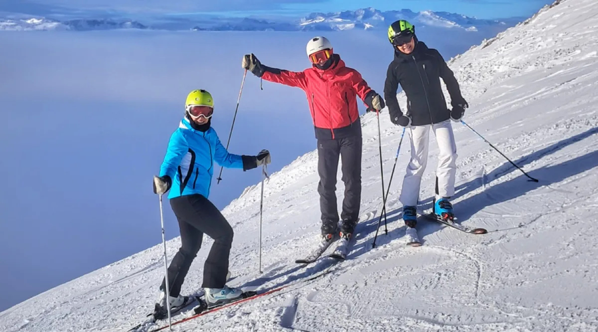Grupo de esquiadores adultos con su profesor sobre un mar de nubes en Baqueira-Beret