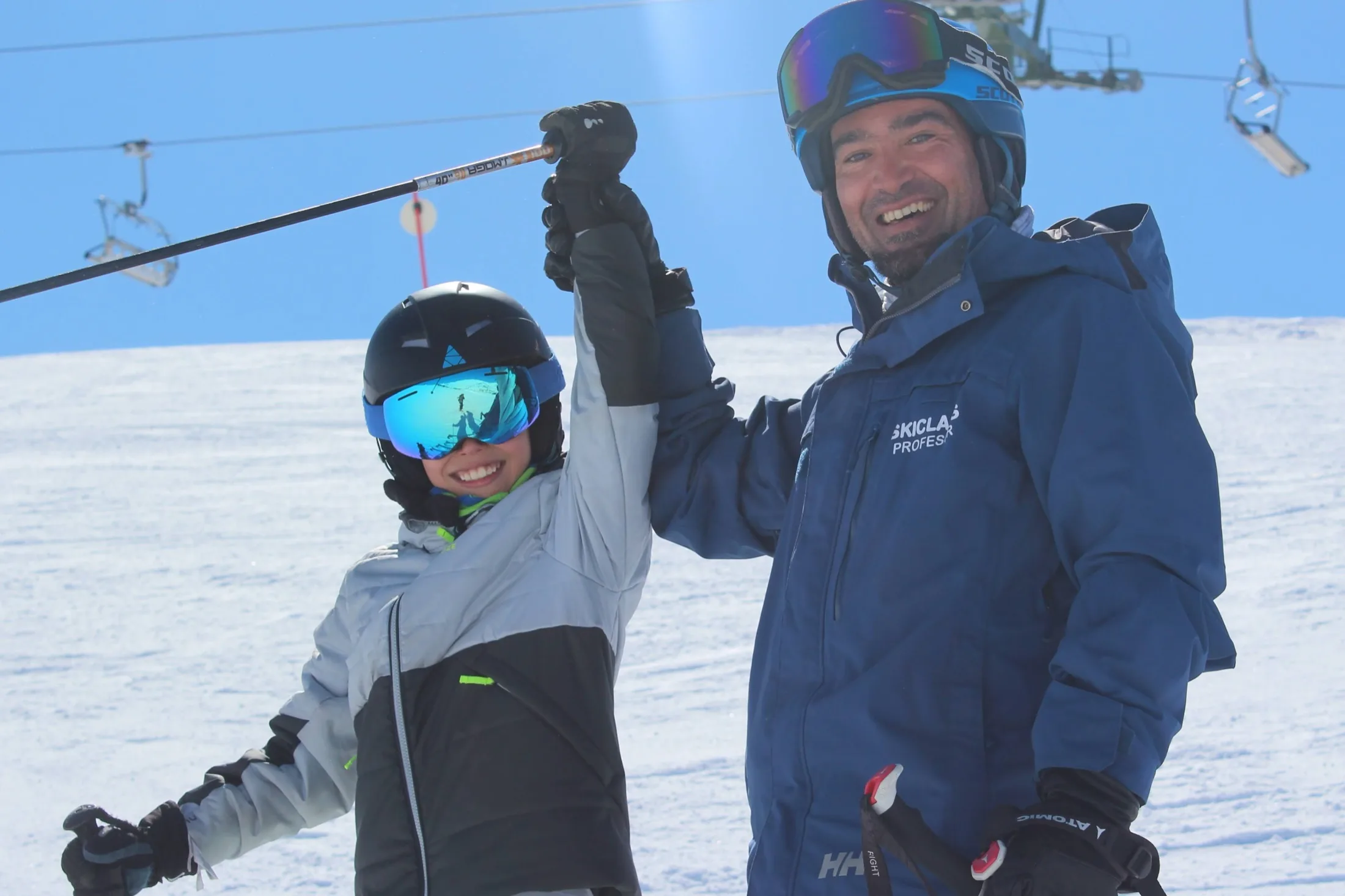 Profesor y alumno celebrando su clase particular de esquí en Baqueira