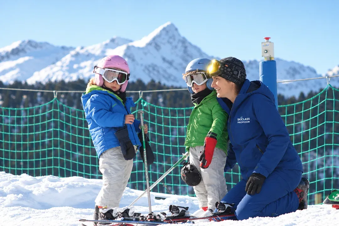 Professora de SkiClass amb dos nens petits en una classe particular d'esquí a Baqueira