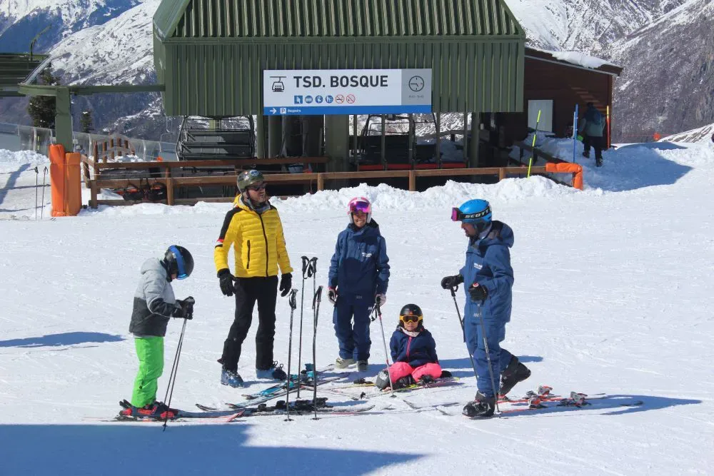 Family with two SkiClass instructors next to the Bosque chairlift in Baqueira