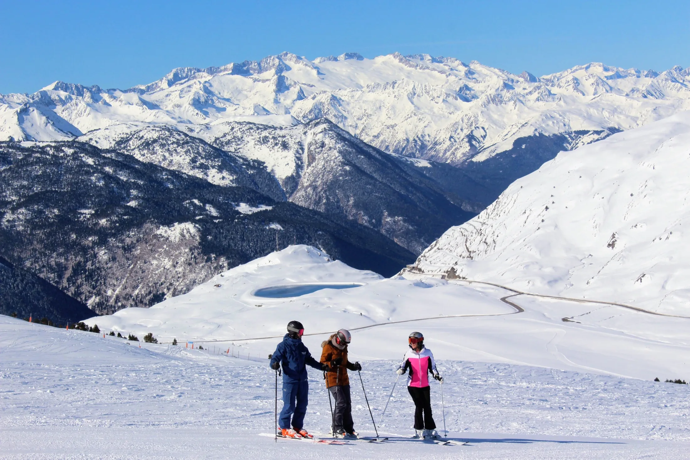 Profesor guía de SkiClass con esquiadores frente al valle de Arán